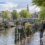 Coppia over 50 passeggia lungo un canale di Amsterdam vicino a un tram