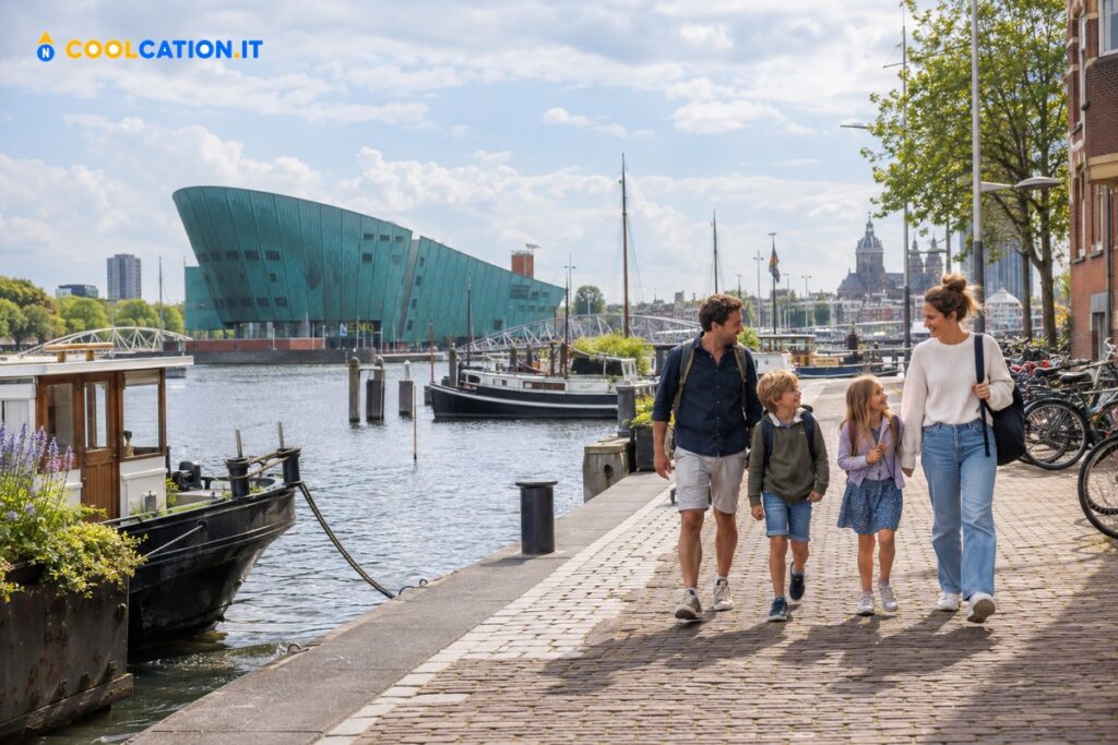 Famiglia con bambini passeggia sul lungomare di Oosterdok davanti al NEMO di Amsterdam